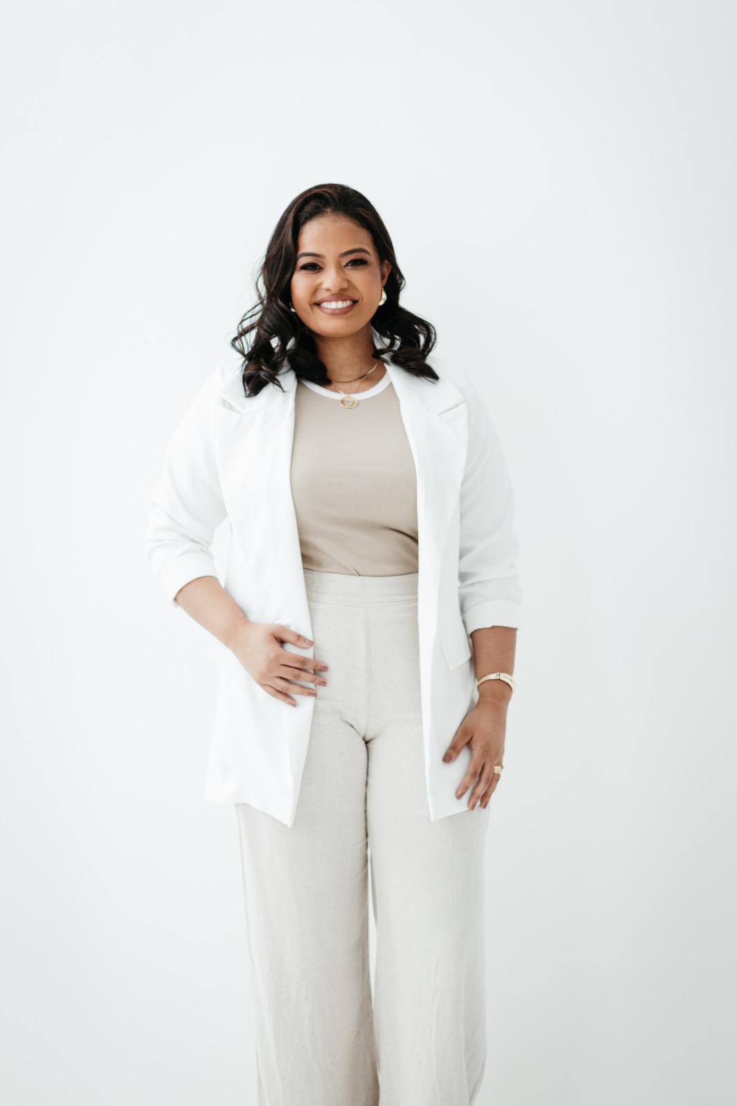 Amanda Stefhane em pé, com blazer branco